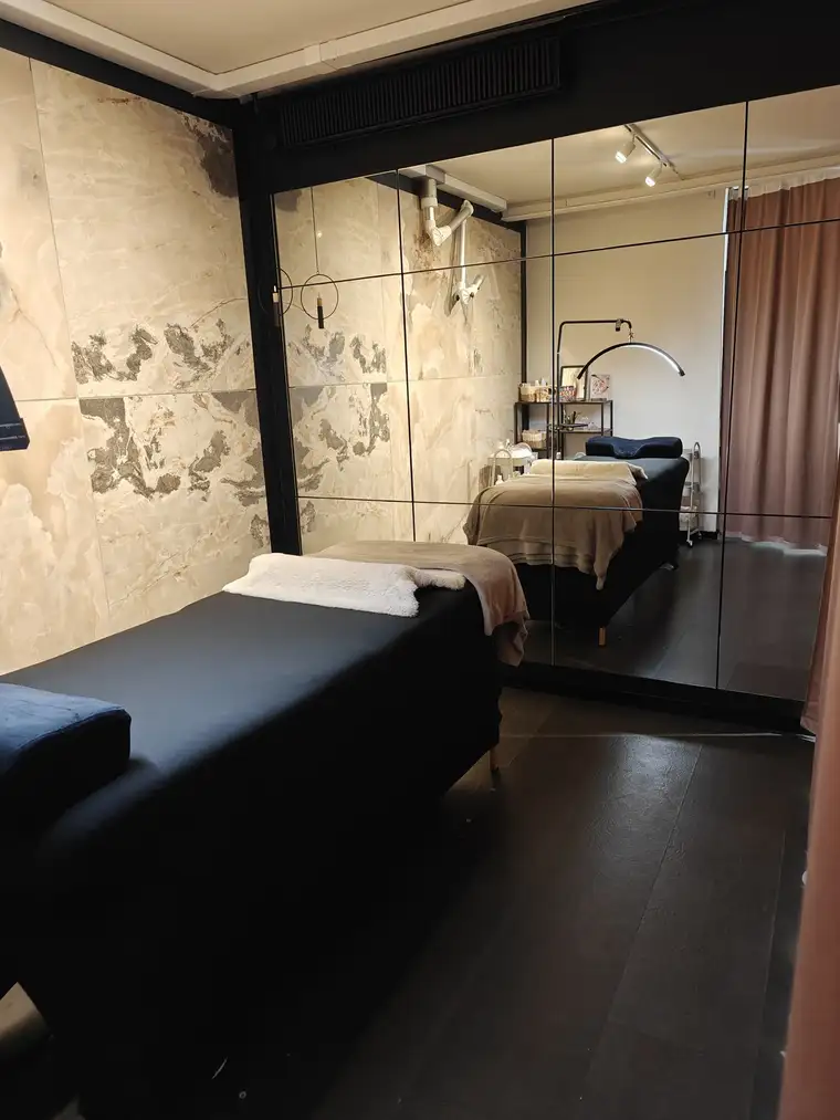 Behandlingsrummet hos Salon Belleza med briks og marmorvæg